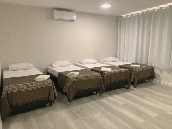 Quarto Quádruplo Solteiro com quatro camas de solteiro lado a lado